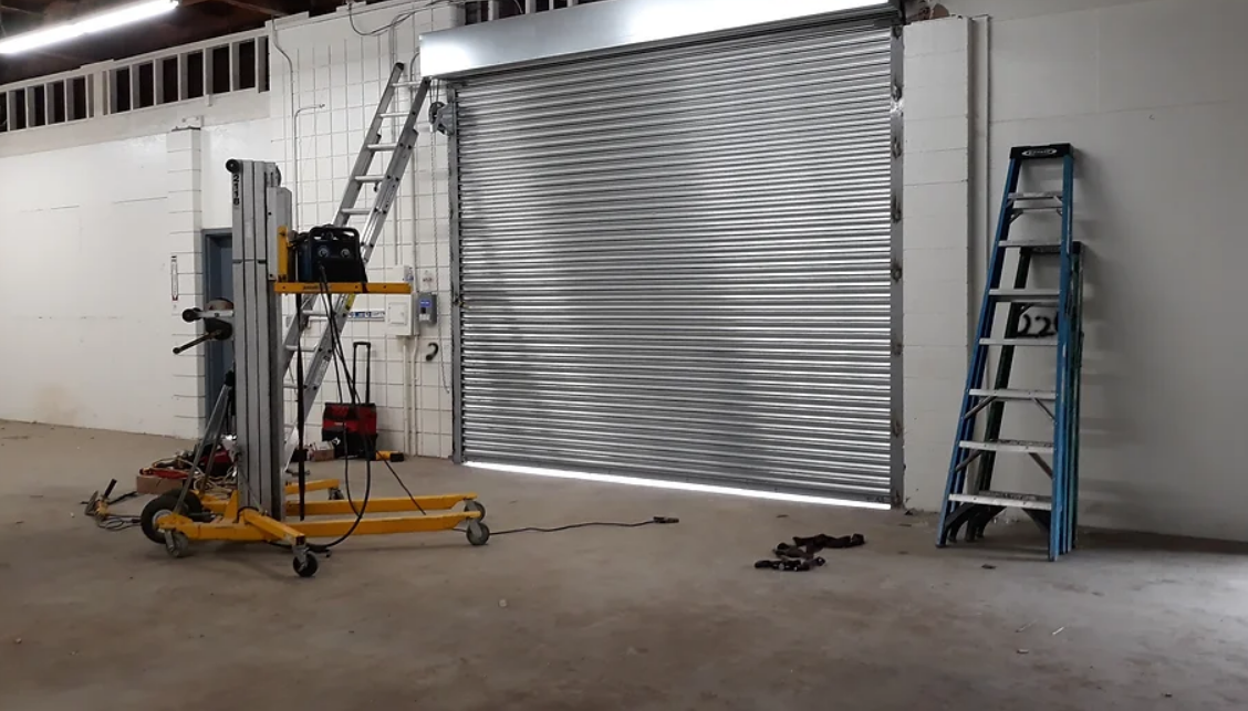 Technician performing commercial garage door repair in Dublin, ensuring smooth operation and functionality of a large industrial garage door.