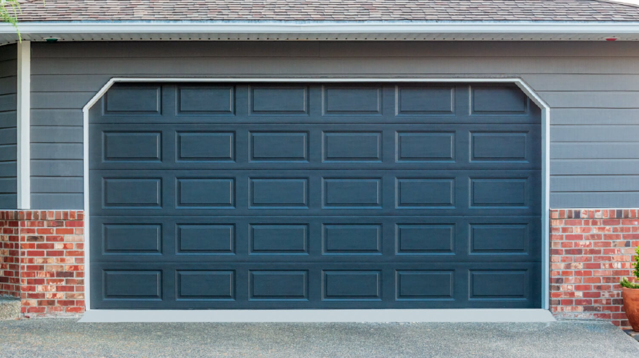 Professional technician diagnosing a residential overhead garage door tracking system structure in Ashville OH